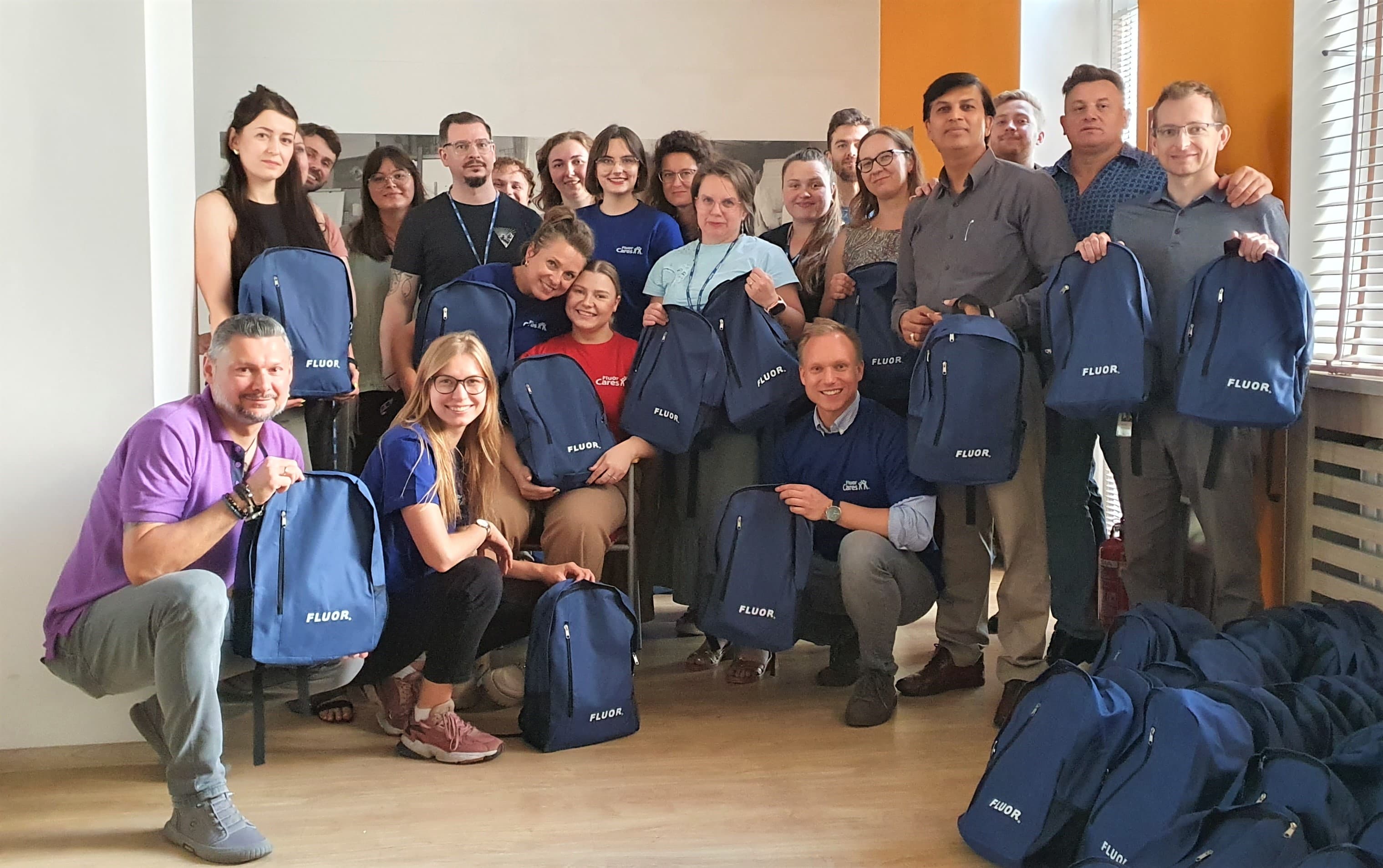 Fluor volunteers with backpacks containing donated school supplies