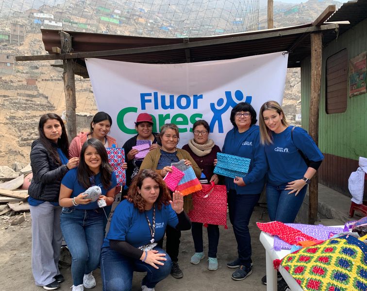 Fluor volunteers with women and handmade textile products