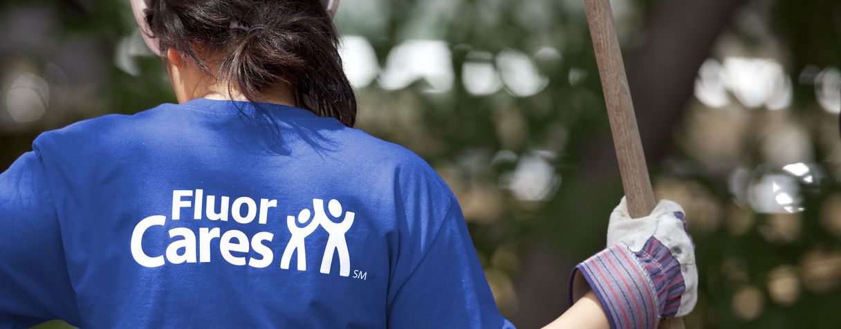 Woman with blue Fluor Cares t-shirt and landscaping tool